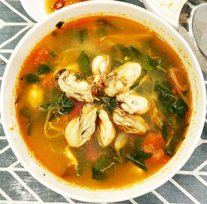 Một tô canh hàu cà chua nóng hổi đã hoàn thành, sẵn sàng để thưởng thức