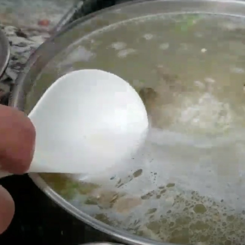 Nấu cháo cá mú trên bếp, khuấy đều tay để cháo không bị khét