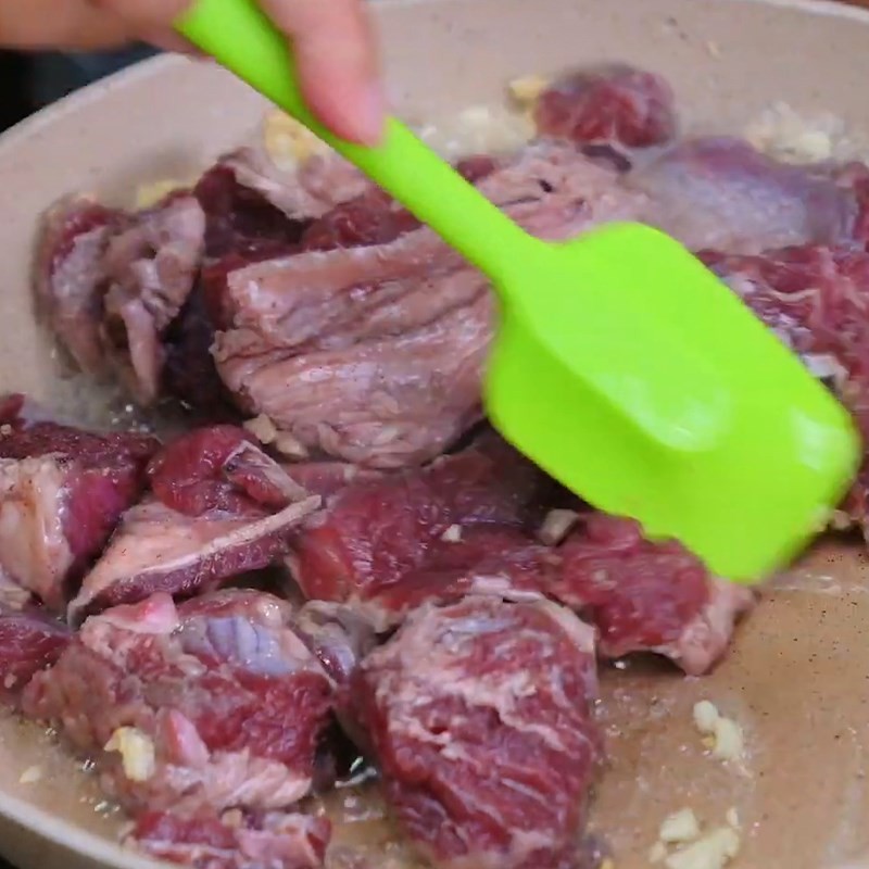 Thịt bò đang được xào trên chảo với tỏi phi thơm